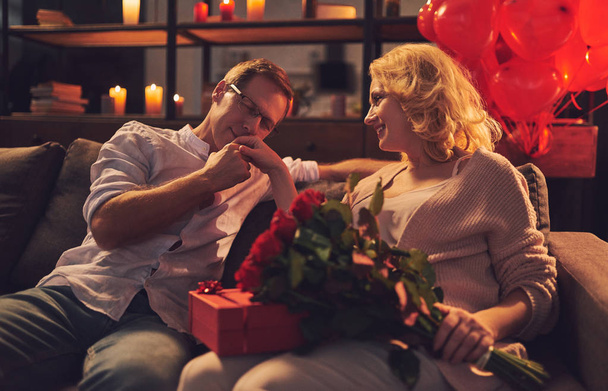 Love has no age! Romantic senior couple celebrating Saint Valentine's Day at home. Beautiful woman and handsome man enjoying spending time together. Happy Saint Valentine's Day! - 写真・画像