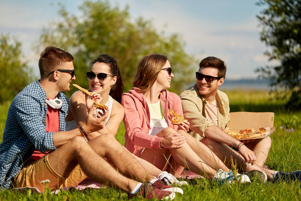 friends eating pizza at picnic in summer park - Fotoğraf, Görsel