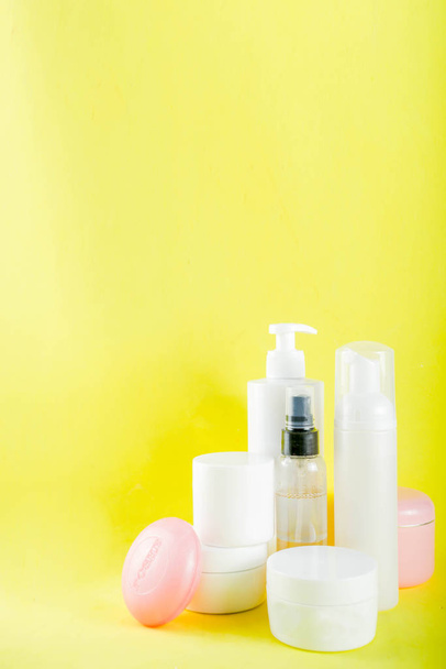 Personal care concept, cosmetics bottles, jars. Skin care products. Relax and spa. On a bright yellow background. - Photo, Image
