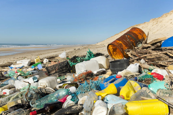 Kosza plaży zanieczyszczenia. Plastikowe, śmieci, odpady na piasku po zimowe sztormy. Atlantyku zachodnim wybrzeżu Francji. - Zdjęcie, obraz