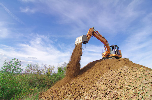 Máquina excavadora en acción durante las obras de movimiento de tierra
.  - Foto, Imagen