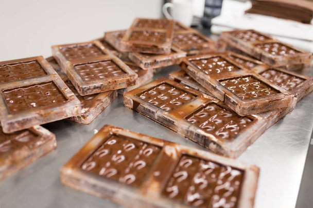 chocolate in candy molds at confectionery shop - Foto, afbeelding