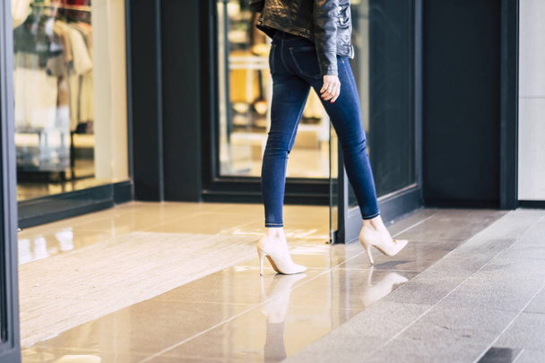 Moda mulher andando em jeans skinny stretch fora de uma loja após a atividade comercial na cidade  - Foto, Imagem