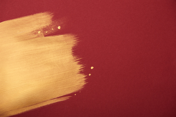 artistic burgundy wallpaper with golden brushstroke and copy space - 写真・画像