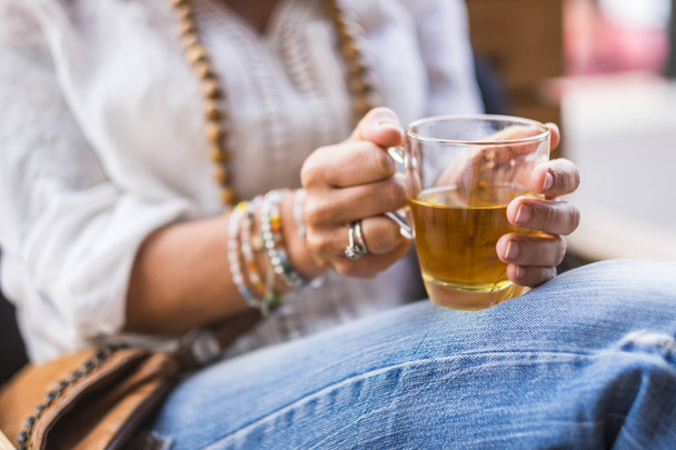 Закройте женские руки чаем в бокале, чтобы согреться и расслабиться  - Фото, изображение