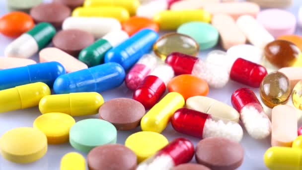 Medische multi-gekleurde tabletten draaien op de tafel - Video