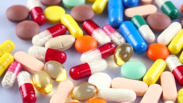 Los comprimidos médicos multicolores giran sobre la mesa
 - Metraje, vídeo