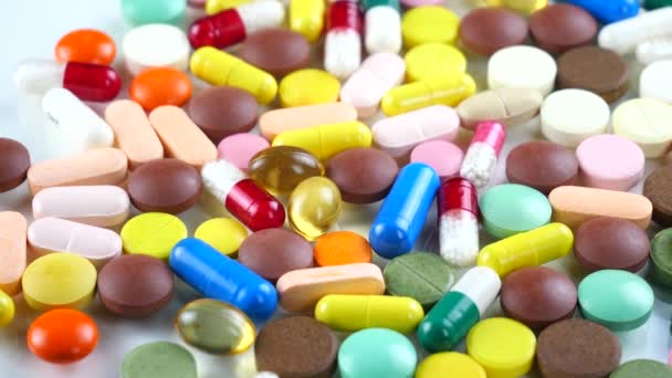 Los comprimidos médicos multicolores giran sobre la mesa
 - Metraje, vídeo