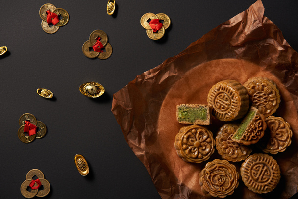 top view of mooncakes with feng shui coins isolated on black - Photo, Image
