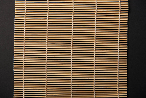 top view of bamboo table mat isolated on black - Foto, Imagen