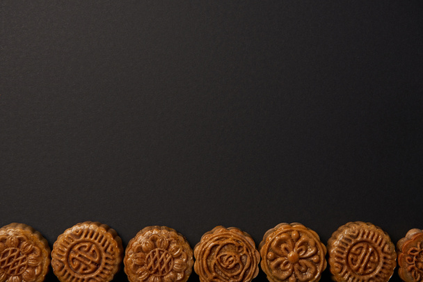 vista superior de mooncakes chineses tradicionais isolados em preto com espaço de cópia
 - Foto, Imagem