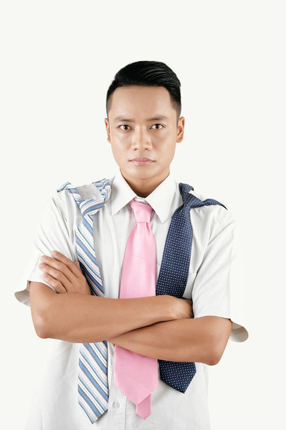 Portrait of young Asian man with several neckties holding hands crossed and looking at camera isolated on white background - Photo, Image