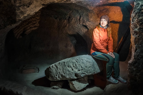 Woman piękny turysta Poznaj długi wąski tunel w starożytnego miasta Derinkuyu podziemnej jaskini. Podróż do Turcji - Zdjęcie, obraz