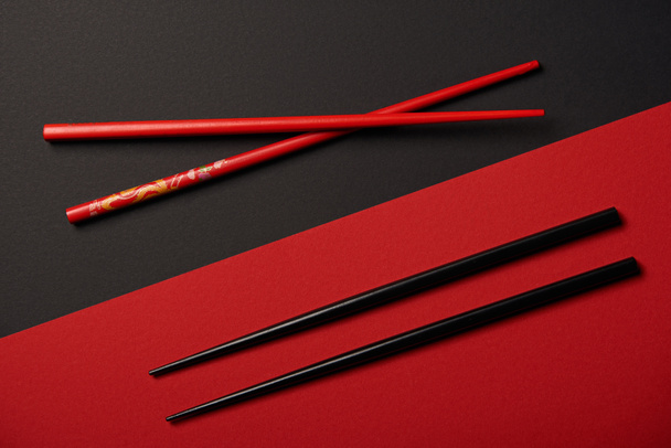 vista superior de dos juegos de palillos sobre fondo rojo y negro
 - Foto, imagen