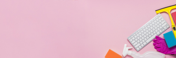 Produits de nettoyage, gants en caoutchouc, éponges, grattoir de fenêtre et clavier sur fond rose. Concept call d'une entreprise de nettoyage via Internet, formation en ligne. Bannière. Couché plat, vue du dessus
 - Photo, image