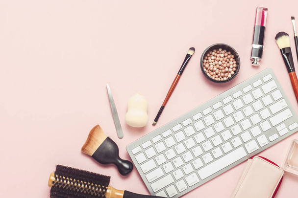 Maquillaje y herramientas de belleza, teclado sobre fondo rosa. El concepto de formación en línea, ordenar cosméticos en la tienda en línea, maquillaje, pruebas. Piso tendido, vista superior
 - Foto, imagen