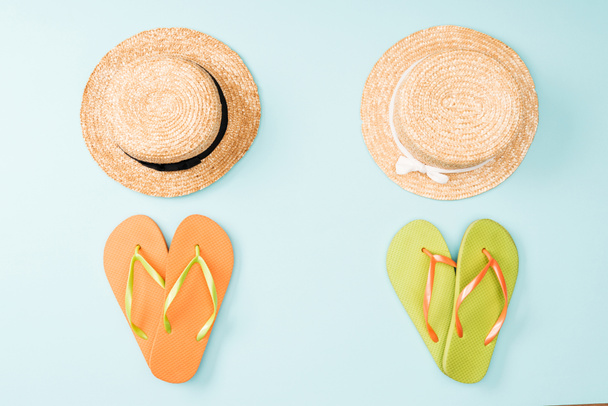 top view of straw hats and flip flops on blue background - Fotografie, Obrázek