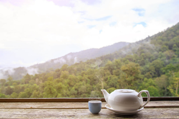 Τσάι κατσαρόλα και φλιτζάνι ζεστό ή ζεστό σε ξύλινο τραπέζι με αντίγραφο χώρου φόντο φύση. - Φωτογραφία, εικόνα