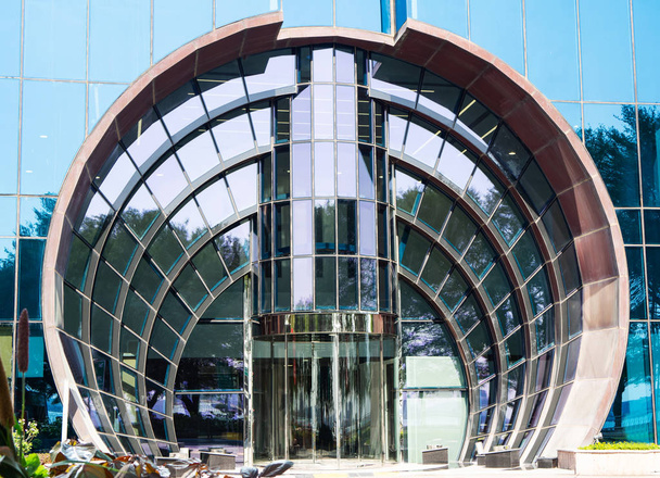Rounded glazed entrance with rotating door in modern skyscraper, close up - Foto, immagini