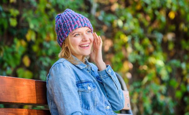 Feel comfortable this fall with soft and warm stylish hat. Knitted accessory for fall season. Autumn fashion accessory. Woman sit bench park nature background. Girl wear knitted hat accessory - Photo, Image