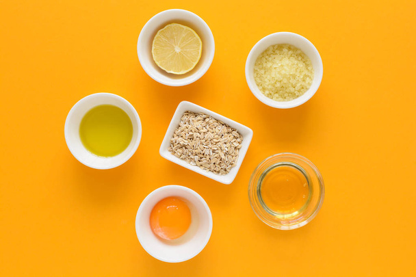 Fresh ingredients for homemade effective acne remedies on yellow background. Honey, sea salt, egg yolk, olive oil, oat, lemon and aloe. Flat lay. Copy space - Zdjęcie, obraz