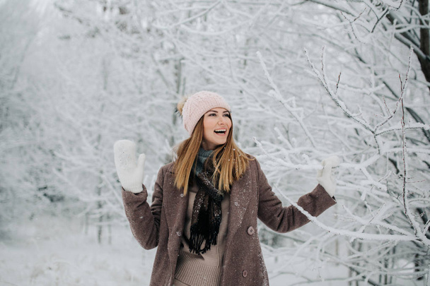 Portrait of smiling woman in hat on walk in winter forest - Φωτογραφία, εικόνα