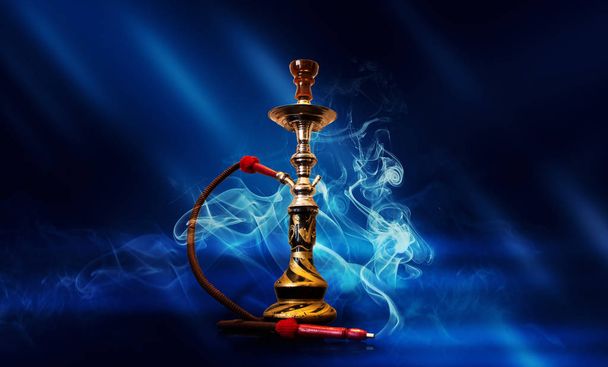 Vízipipa-dohányzás neon sugarak, füst, futurisztikus kék háttérrel reflektorfénybe - Fotó, kép
