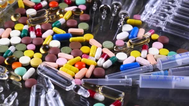 Orvosi fecskendők és sokszínű tabletták forgatni az asztalon - Felvétel, videó