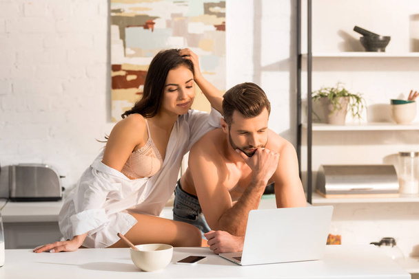 selective focus of beautiful sexy couple using laptop during breakfast at home - Fotoğraf, Görsel