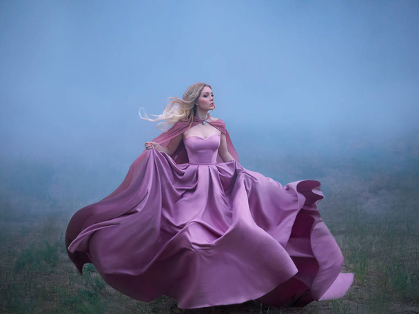 excellent mysterious blonde lady runs away from a nightmare, a forest monster, her light long expensive royal dress flutters on the fly, takes the form of a magical flower an amazing photo in motion - Photo, image