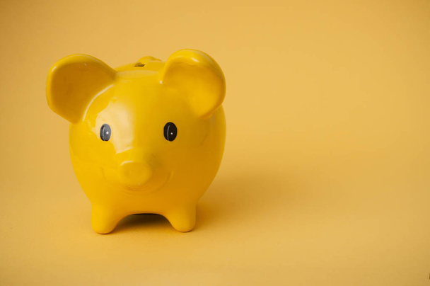 closeup of yellow piggy bank on yellow background  - Foto, afbeelding