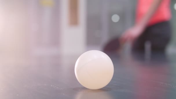 Jonge vrouw toenadering zoekt tot een tafeltennistafel, een bal en begint te spelen - Video