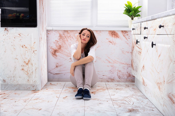 Sad Woman Sitting On Floor With Spilled Food In Kitchen - Fotoğraf, Görsel