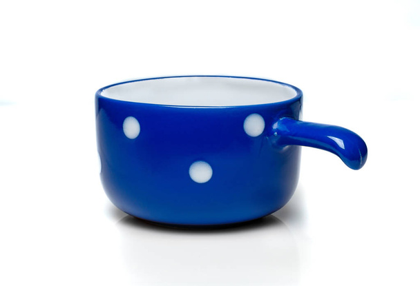 Blue cup with white polka dots on a white background - Foto, imagen