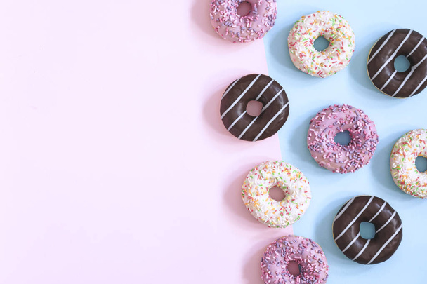 Collection of glazed donuts on pastel blue and pink background - Foto, Imagem