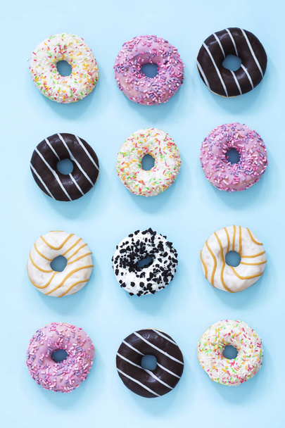 Collection of glazed donuts on pastel blue background - Foto, Imagem