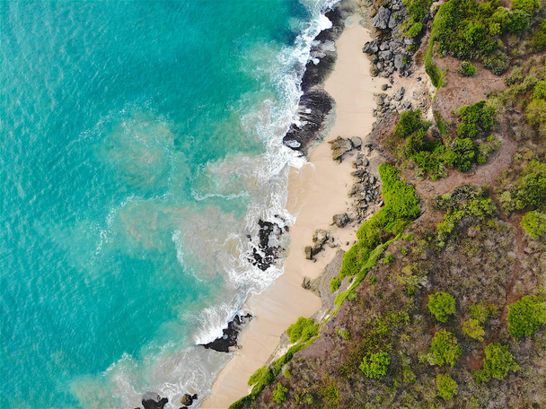 Veduta aerea del mare blu con scogliera rocciosa sulla costa sabbiosa. Bella acqua di mare turchese con onde per il surf nella stagione estiva a Bali. Bellezza Oceano Indiano paesaggio, meta di vacanza
 - Foto, immagini