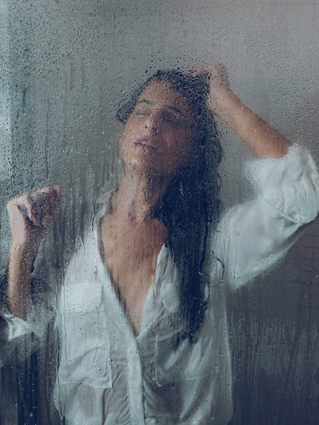 Sopping donna in camicia posa in cabina doccia
 - Foto, immagini