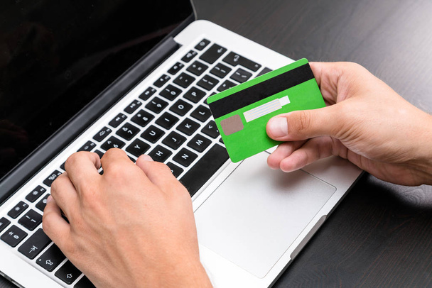若いビジネス人がコンピューターのキーボード上のクレジット カード情報を入力します。クレジット カードの表示手に。クローズ アップ、ビジネス オフィス職場。債務、手形、デビット カード情報、オンライン銀行、住宅ローンの支払い - 写真・画像