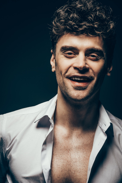 happy handsome man posing in white shirt isolated on dark grey - Fotografie, Obrázek
