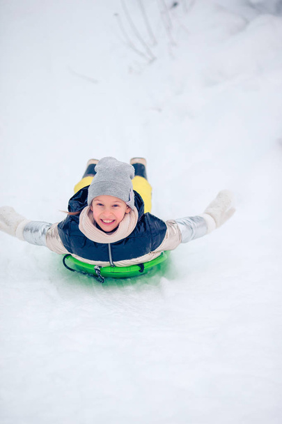 Adorable niña feliz trineo en invierno día nevado
. - Foto, Imagen