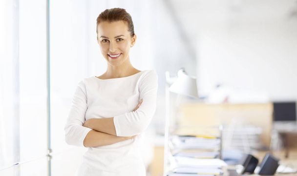 Shot of a young marketing assistant businesswoman standing with arms crossed at the office.  - Фото, зображення