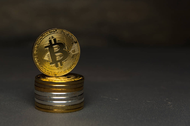  golden bitcoin stand on pile of coins - Fotó, kép