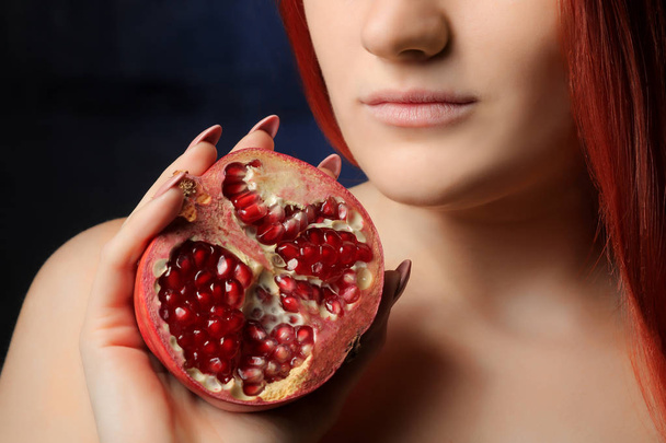 portrait of beautiful girl with red hair and pomegranate fruit on the background of blue wall. different poses. - Photo, Image