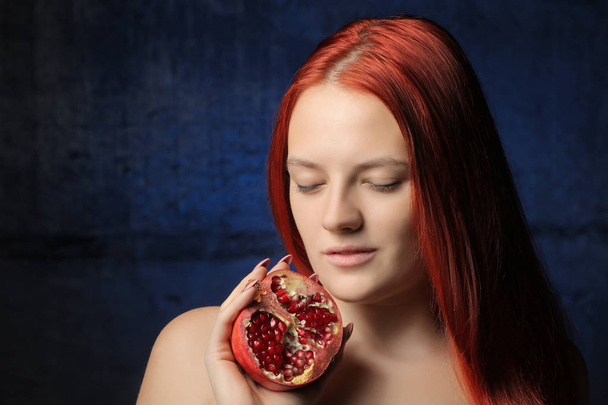 retrato de hermosa chica con el pelo rojo y fruta de granada en el fondo de la pared azul. diferentes posturas
. - Foto, imagen