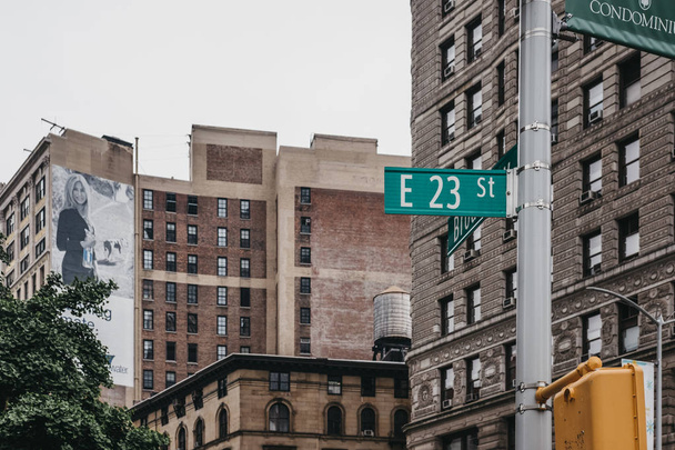 Нью-Йорк, США - 28 мая 2018 года: название улицы и дорожные знаки на фонарном столбе на 23-й Восточной улице в Манхэттене, Нью-Йорк. Нью-Йорк - один из самых посещаемых городов в мире
. - Фото, изображение