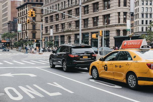 New York, USA - May 30, 2018: Car and yellow taxi waiting on traffic light on street in Manhattan New York, USA. New York is the third most traffic congested city in the world. - Fotó, kép