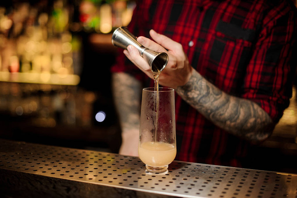 Bartender pouring a portion of alcoholic drink using jigger - Fotografie, Obrázek
