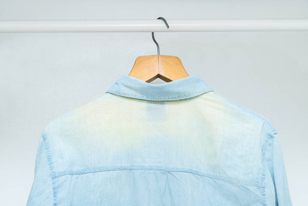 Изношенная, отбеленная старая классическая деловая рубашка, висящая в шкафу
 - Фото, изображение