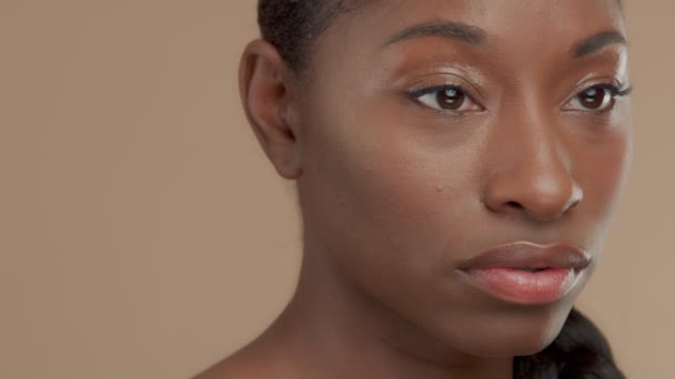 Black mixed race model on beige background with natural neutral makeup - Metraje, vídeo